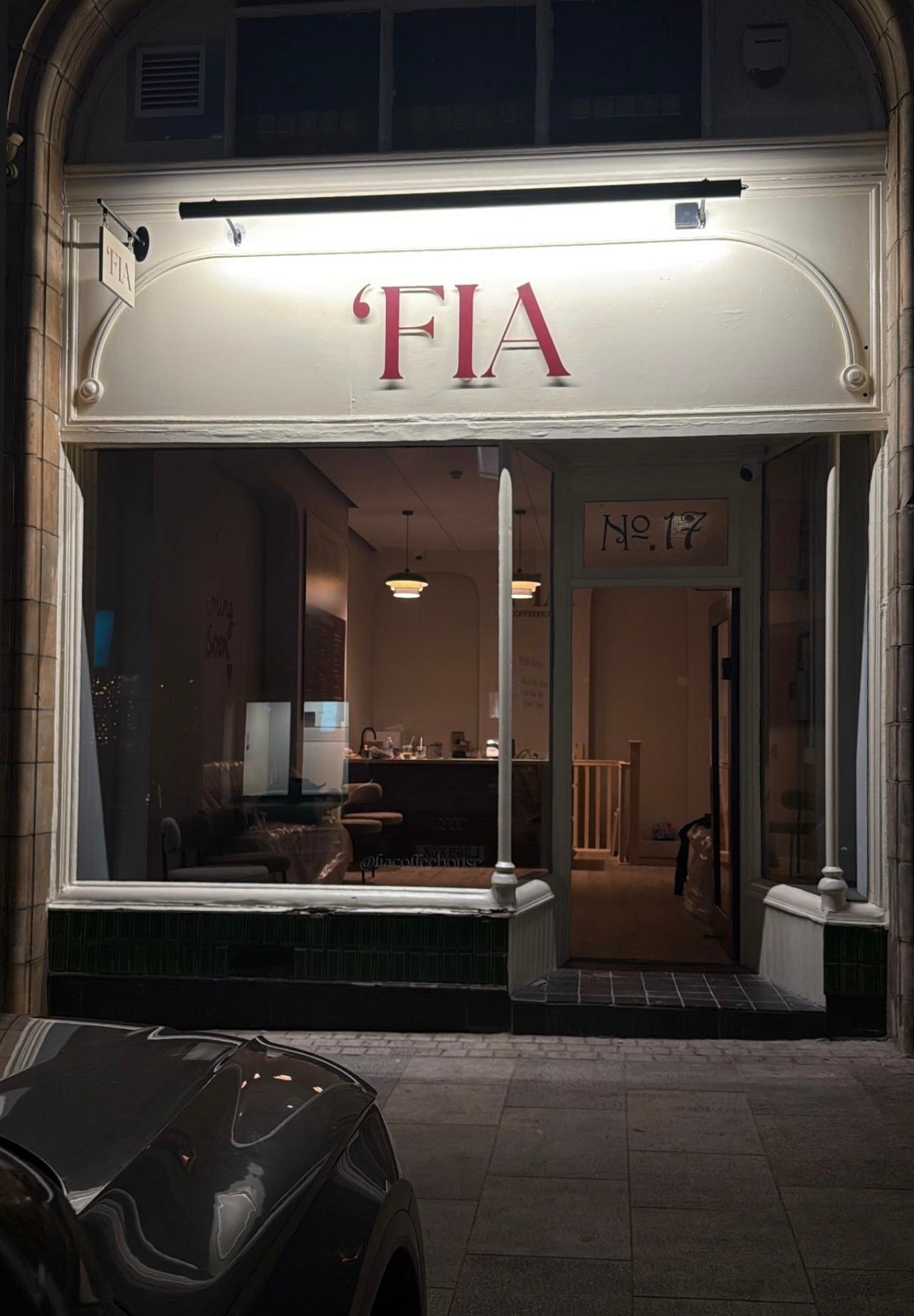 'FIA Coffeehouse shopfront glowing warmly at night